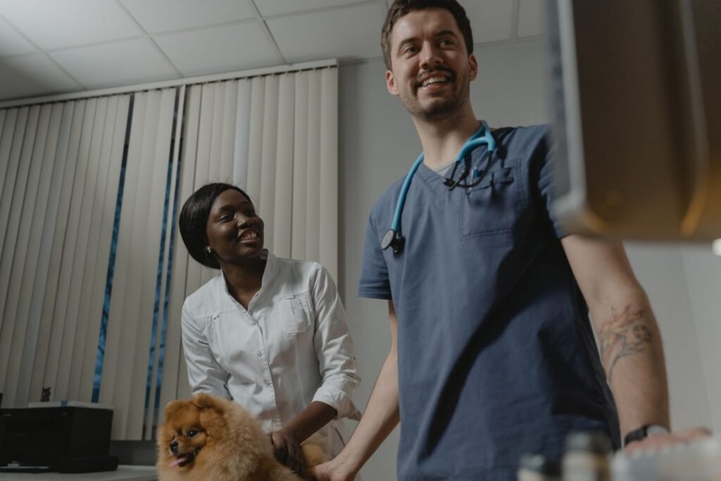 Pet owner holding a small dog beside a veterinarian for microchipping in North Vancouver