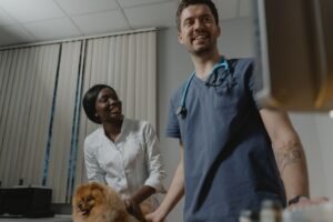 Pet owner holding a small dog beside a veterinarian for microchipping in North Vancouver